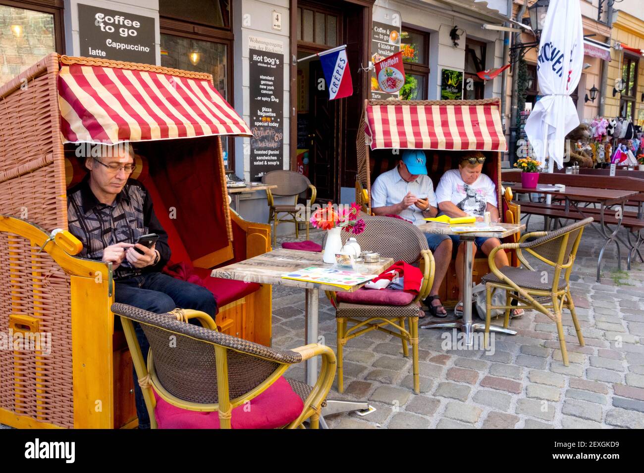 Berlin Deutschland Menschen, Touristen sitzen auf Liegen vor Café & Creperie, Bar im Nikolaiviertel Berlin Stadtteil Lifestyle Menschen Stockfoto