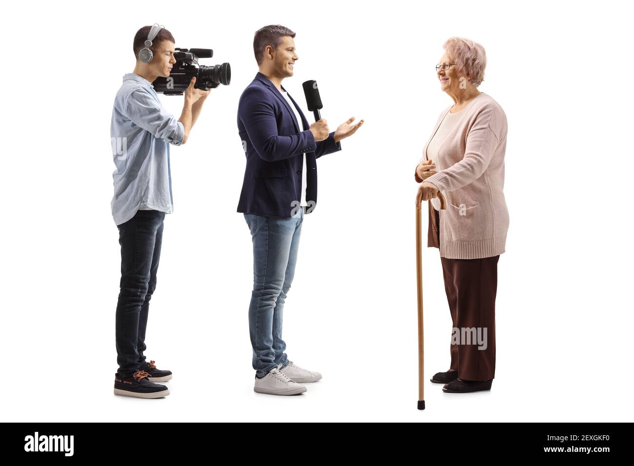 In voller Länge Profilaufnahme eines männlichen Reporters mit einem Mikrofon und ein Kameramann interviewen eine ältere Frau isoliert auf Weißer Hintergrund Stockfoto