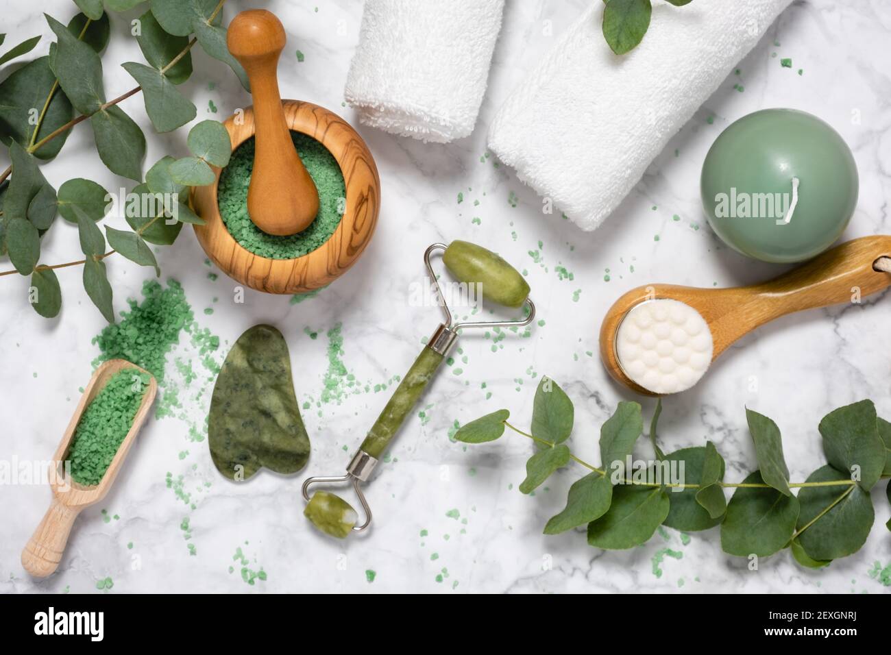 Natürliche Wellness und Anti-Aging-Pflege mit Beauty-Jade-Roller, Gua Sha , Badesalz und Eukalyptus Zweig auf Marmor Hintergrund. Spa, Gesichtsmassage Stockfoto