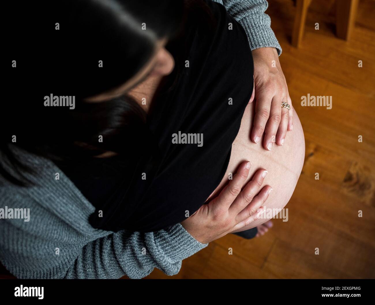 Oben Ansicht der schwangeren Frau berühren Bauch zu Hause mit Hände Stockfoto