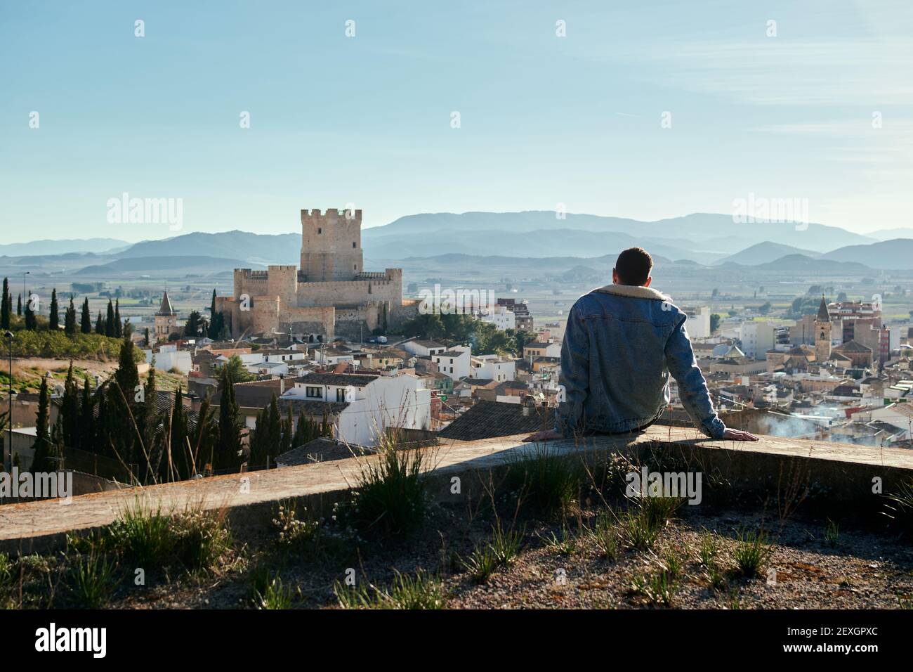 Mann auf einem Dach mit Blick auf die Burg von A Stadt in Spanien Stockfoto
