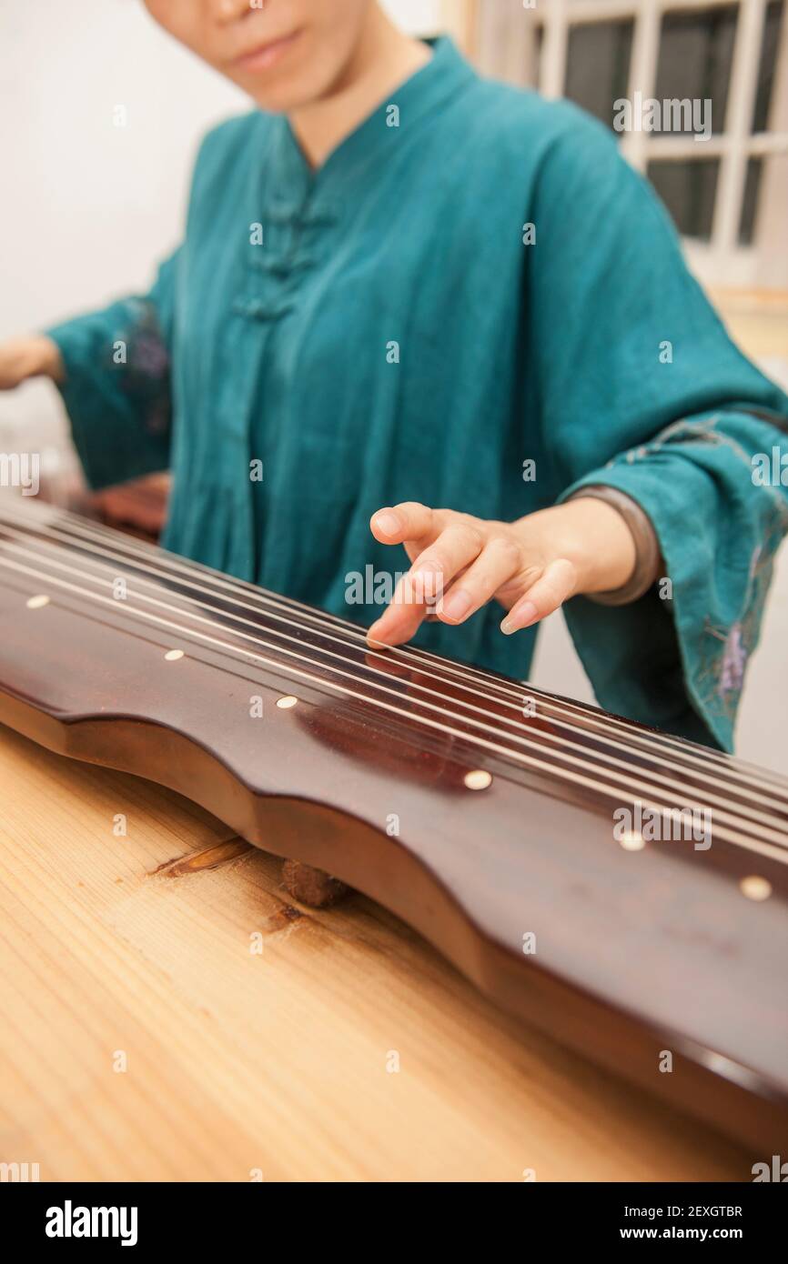 Junge Chinesin spielt traditionelles chinesisches Instrument Stockfoto
