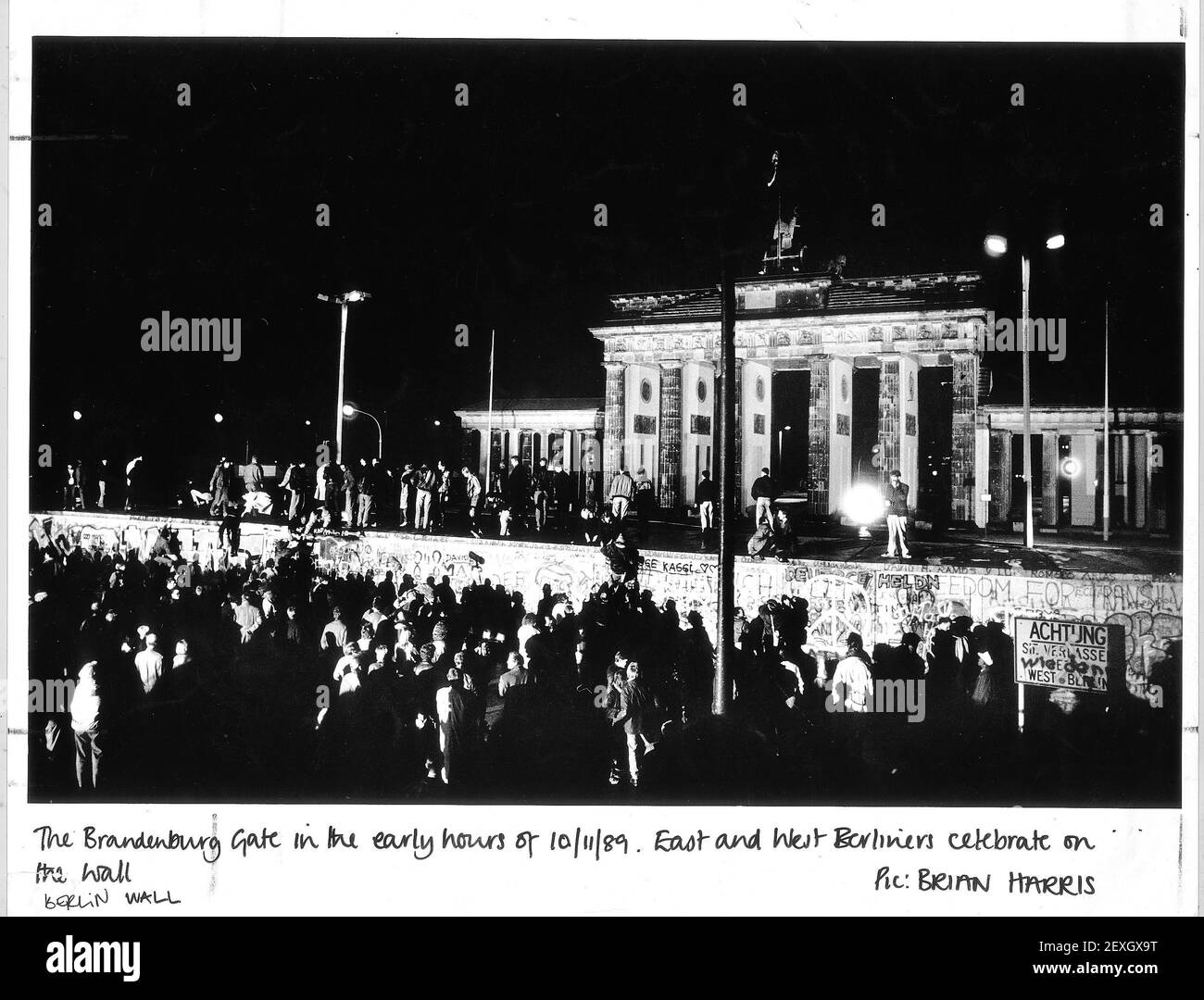 Das Brandenburger Tor in den frühen Morgenstunden des 10/11/89. Ost- und Westberliner feiern an der Wand. Stockfoto