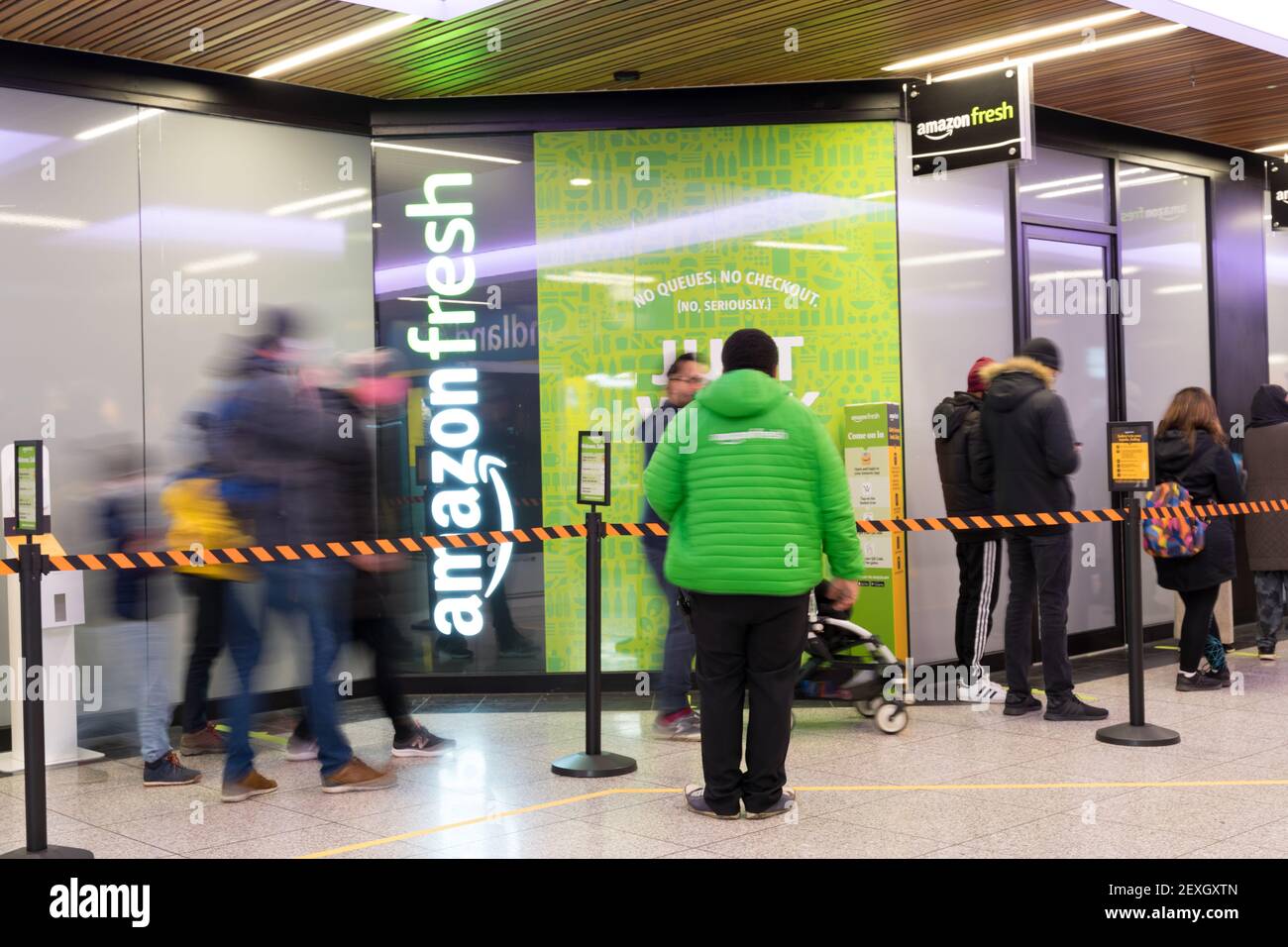 Das Personal begrüßt die Einkäufer in der Schlange zu Amazon Fresh. Es ist das erste Geschäft mit "Just Walk Out" in Ealing London, Großbritannien Stockfoto