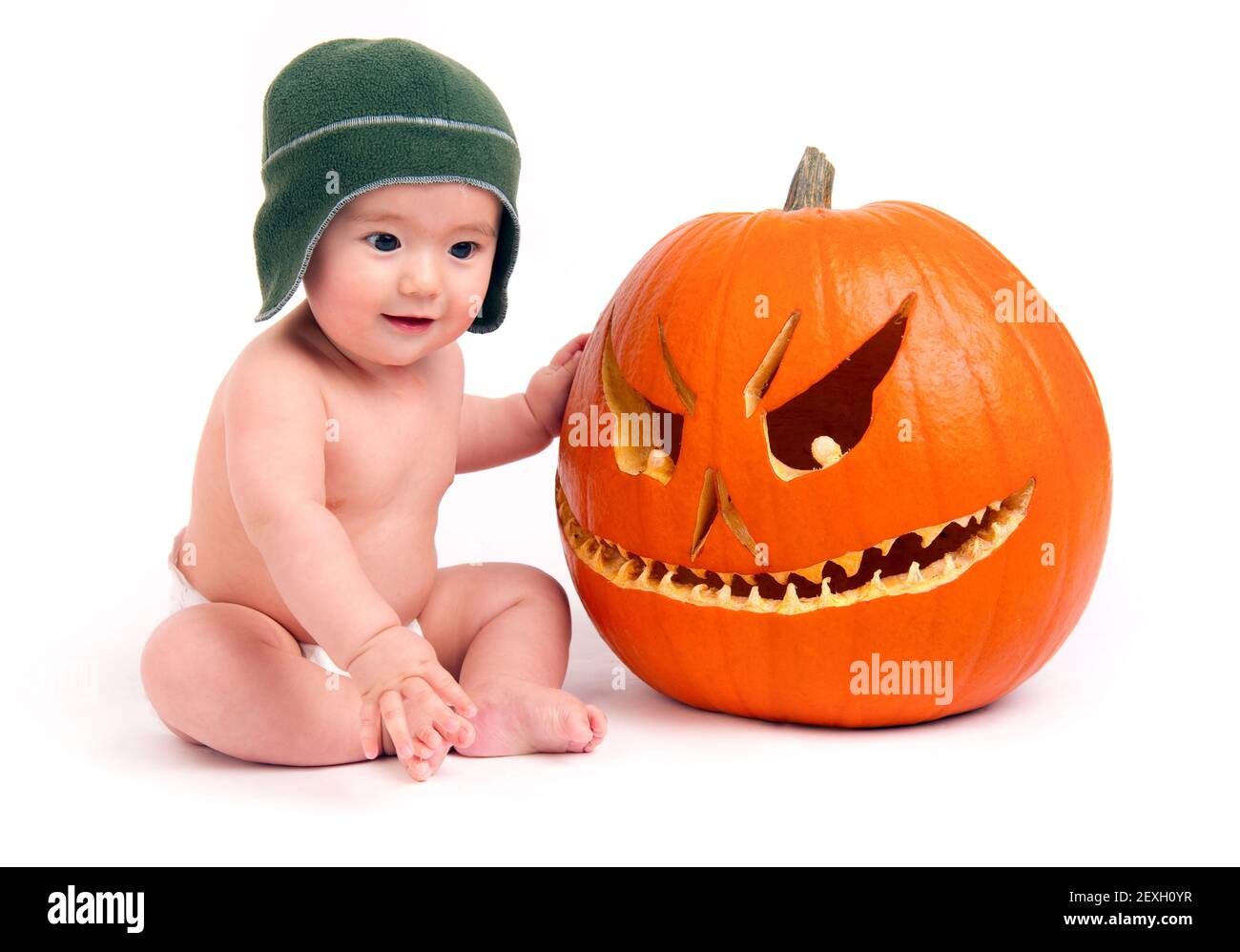 Young Boy sitzt in Windel mit geschnitzten Halloween Kürbis Stockfoto