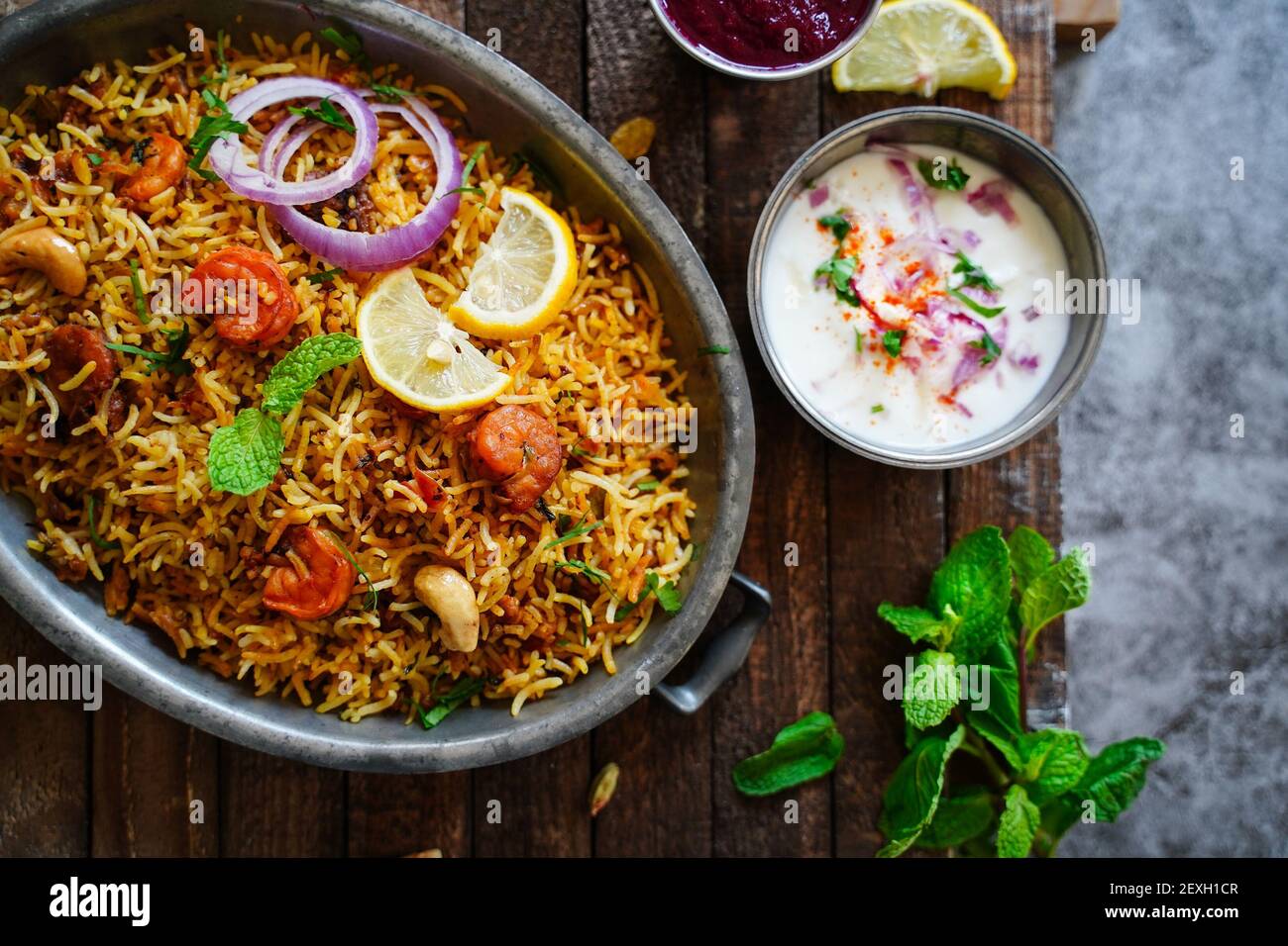 Hausgemachte Garnelen Shrimp biryani serviert mit Joghurt Raita und Rüben Gurkenscheibe Stockfoto