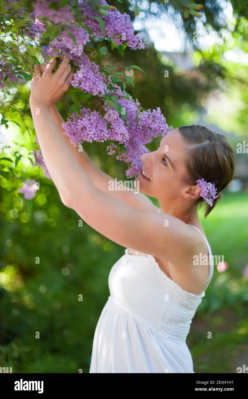 Junge Frau genießt den Duft von Flieder Stockfoto