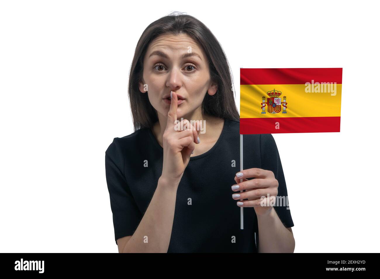 Glückliche junge weiße Frau hält Flagge von Spanien und hält einen Finger an ihre Lippen isoliert auf einem weißen Hintergrund. Stockfoto