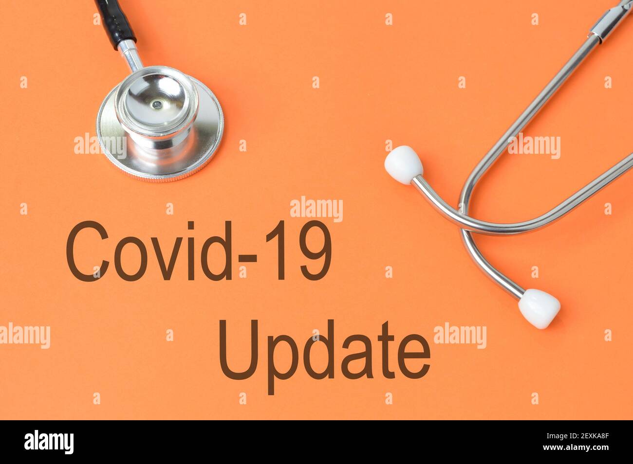 Stethoskop über orangefarbenem Hintergrund geschrieben mit COVID-19 UPDATE. Stockfoto