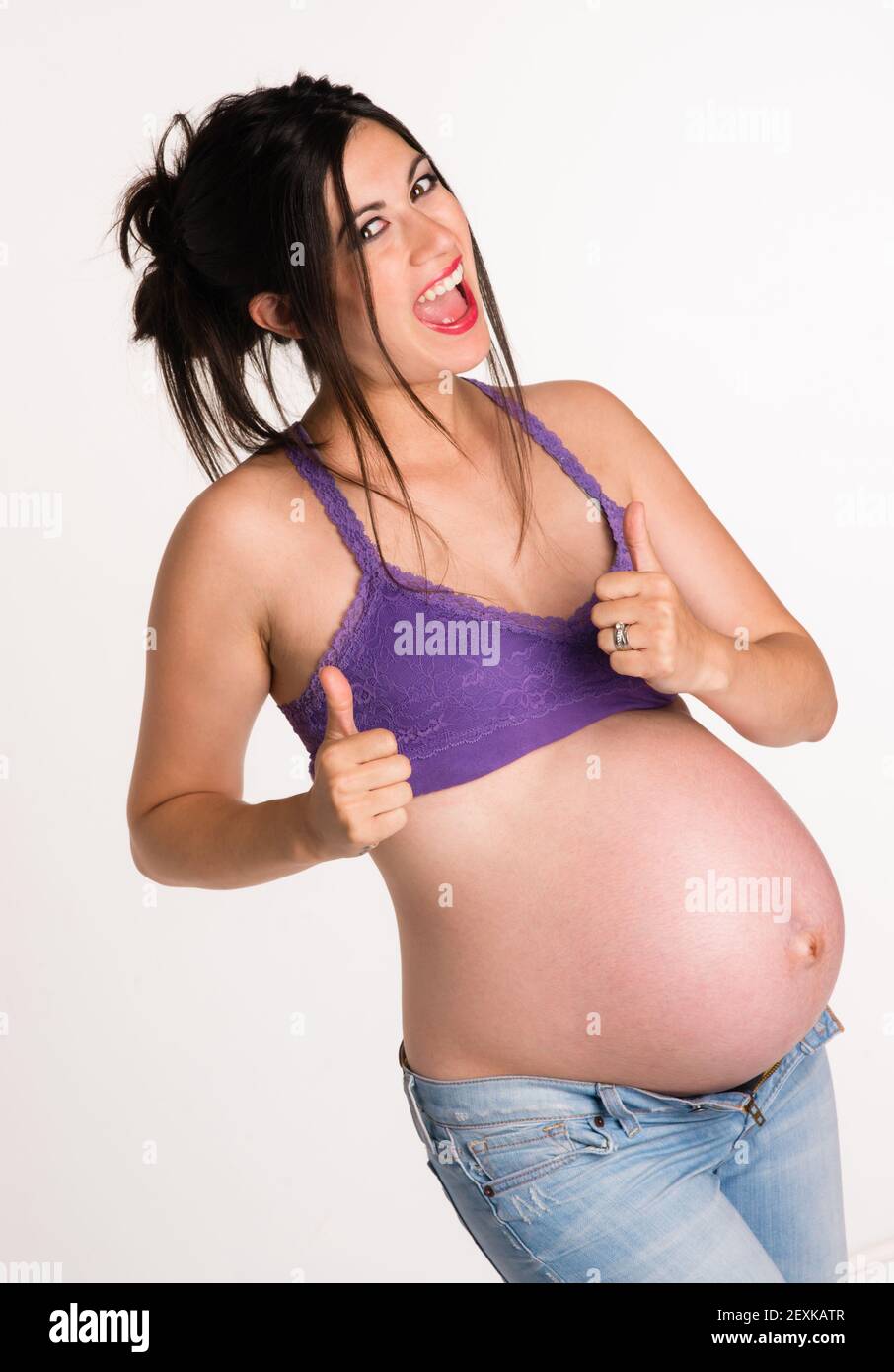 Attraktive schwangere Frau gibt a-OK Hand Signal Daumen nach oben Stockfoto