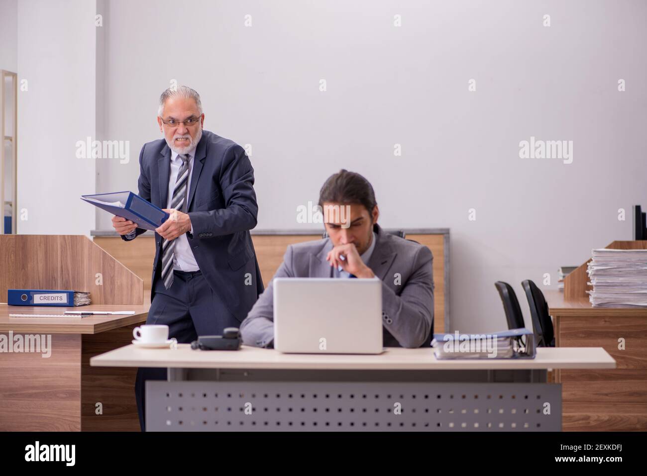 Alter männlicher Chef und junger männlicher Assistent im Büro Stockfoto