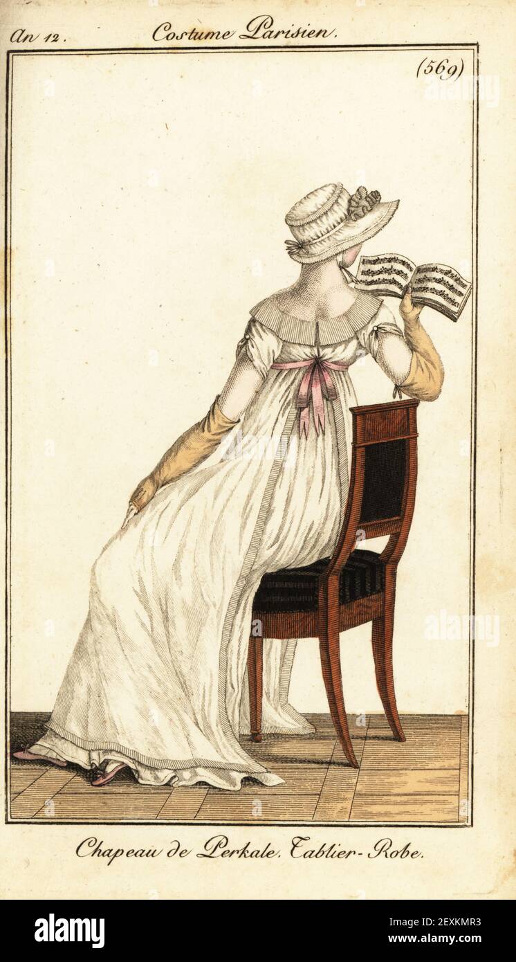 Frau liest eine Partitur auf einem Stuhl sitzend. Sie trägt einen Hut aus Baumwoll-Perkal, ein Schürzenkleid und lange Handschuhe. Chapeau de Perkale. Robe von Tablier. Handkolorierter Kupferstich aus Pierre de la Mesangeres Journal des Dames et des Modes, Magazine of Women and Fashion, Paris, an 12, Juli 1804. Illustrationen von Carle Vernet, Jean-Francois Bosio, Dominique Bosio und Philibert Louis Debucourt, gestochen von Pierre-Charles Baquoy. Stockfoto