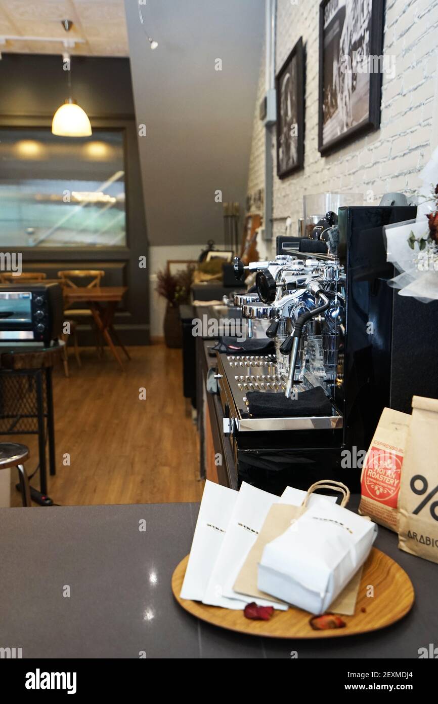 Inneneinrichtung und Dekoration der lokalen Kaffeebar und Bäckerei Konditorei mit antiken Holzmöbeln und weißen Ziegelwänden Stockfoto