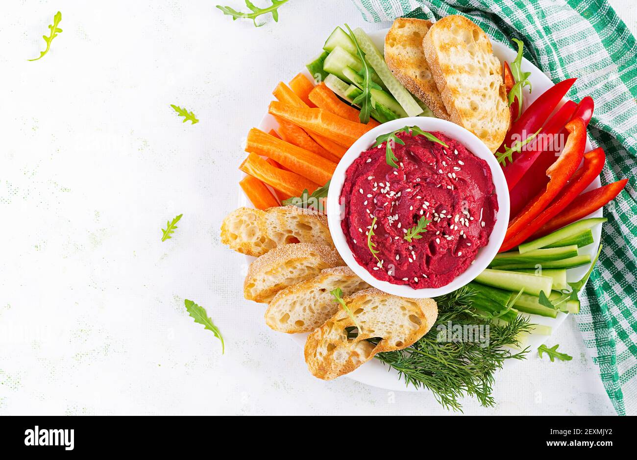 Gerösteter Rübenhummus mit Toast und Gemüse auf hellem Hintergrund. Beetroot Hummus. Draufsicht, oben, Kopierbereich Stockfoto