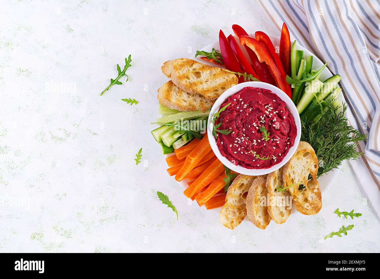 Gerösteter Rübenhummus mit Toast und Gemüse auf hellem Hintergrund. Beetroot Hummus. Draufsicht, oben, Kopierbereich Stockfoto