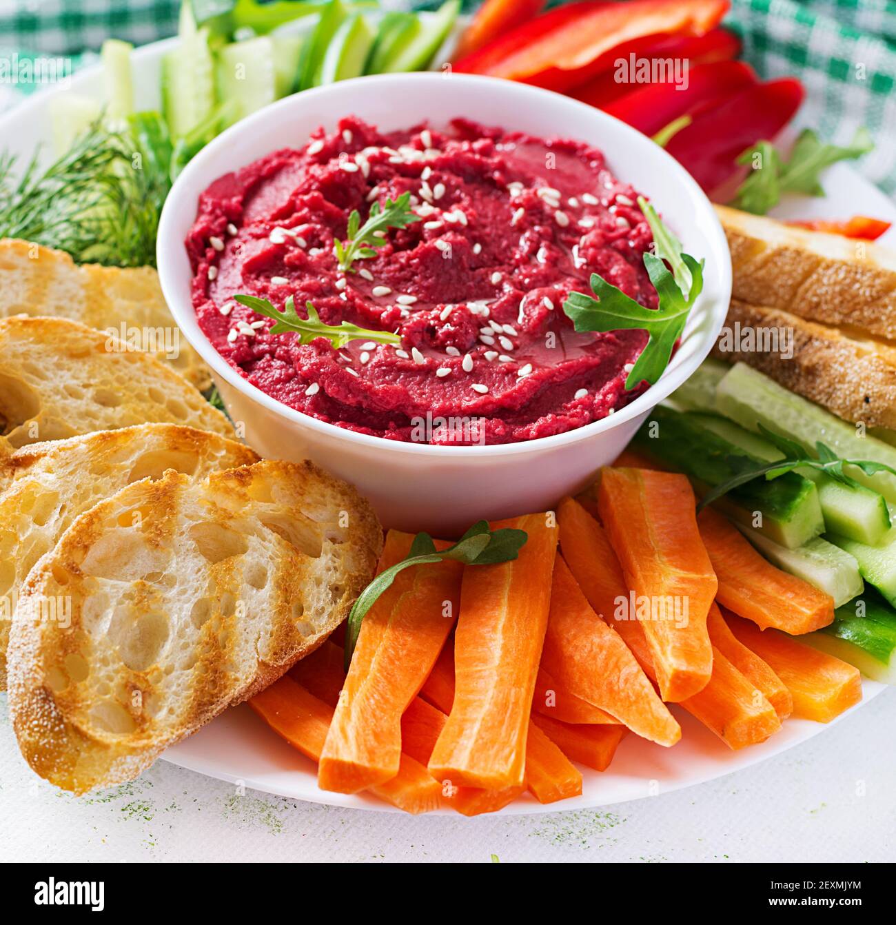 Gerösteter Rübenhummus mit Toast und Gemüse auf hellem Hintergrund. Beetroot Hummus. Stockfoto