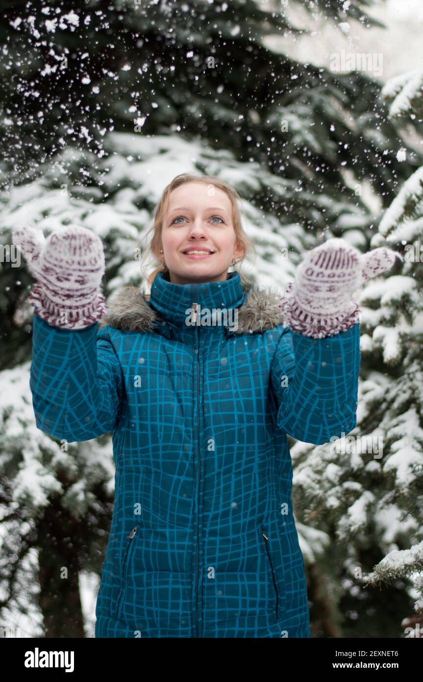 Ein Mädchen in einem Kiefernwald während eines Schneefalls Stockfoto