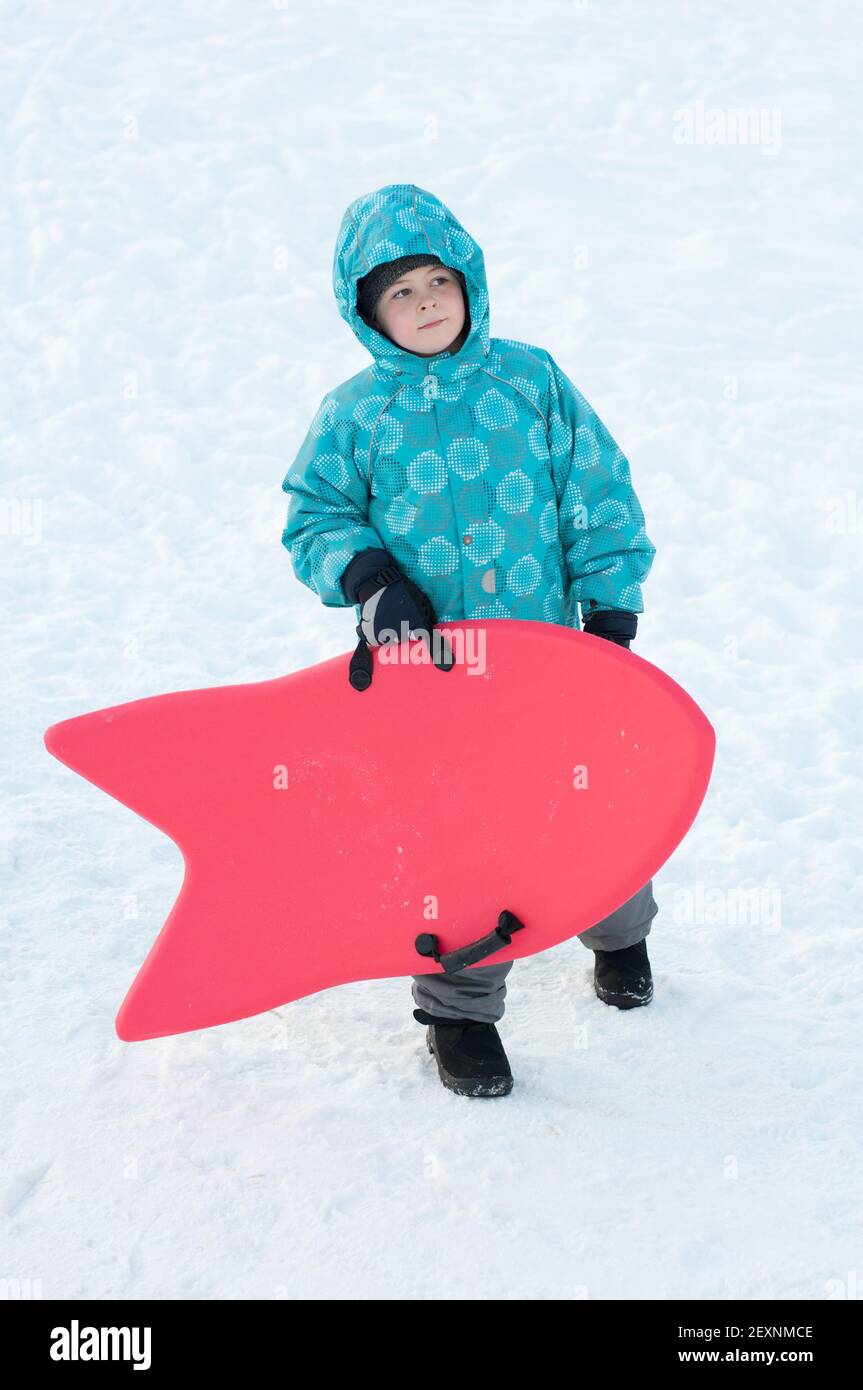 Der Junge mit roten Schlitten im Winter Stockfoto