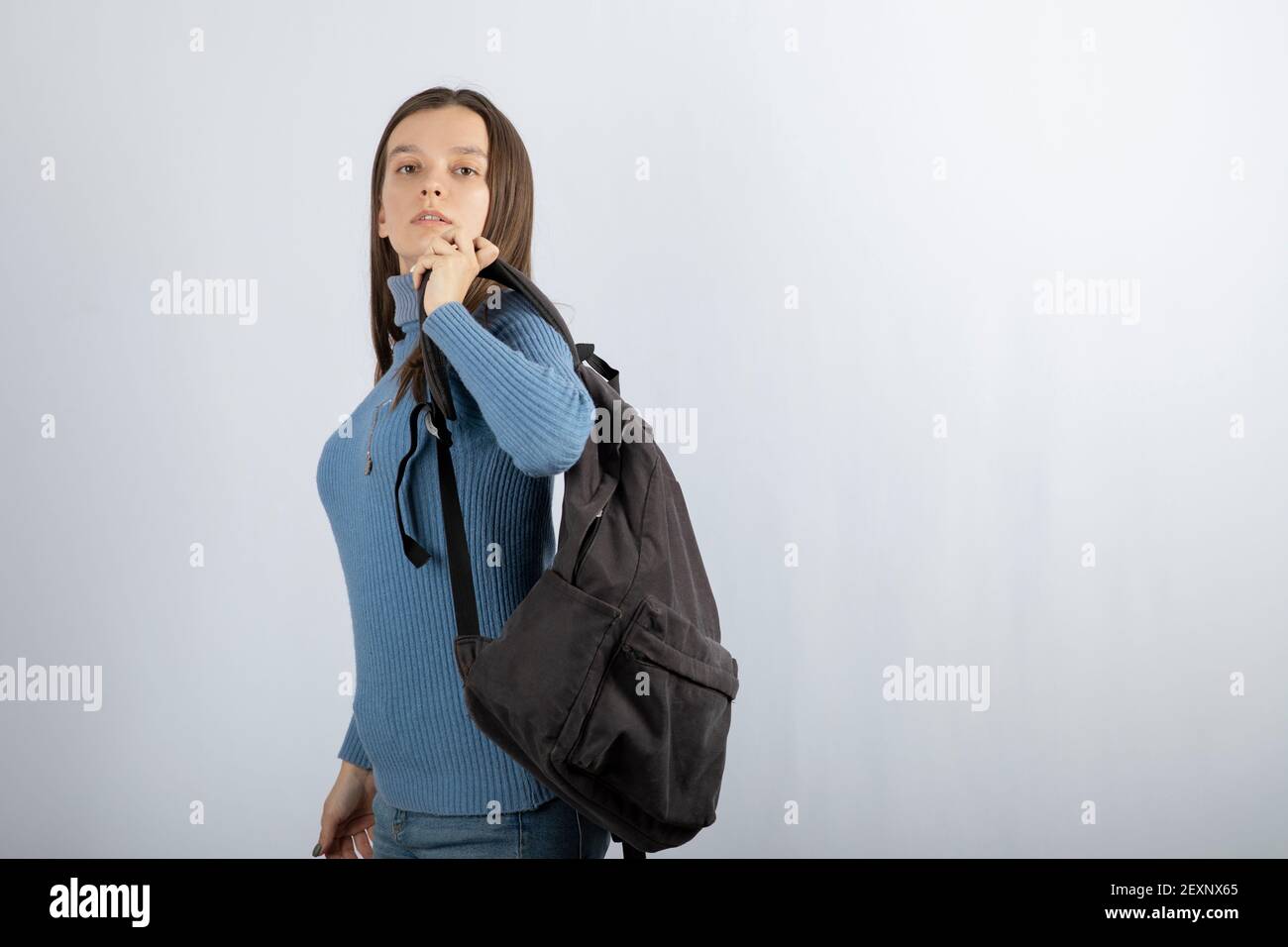 Portrait Foto von einem jungen Mädchen Modell mit Rucksack stehen Und posieren Stockfoto