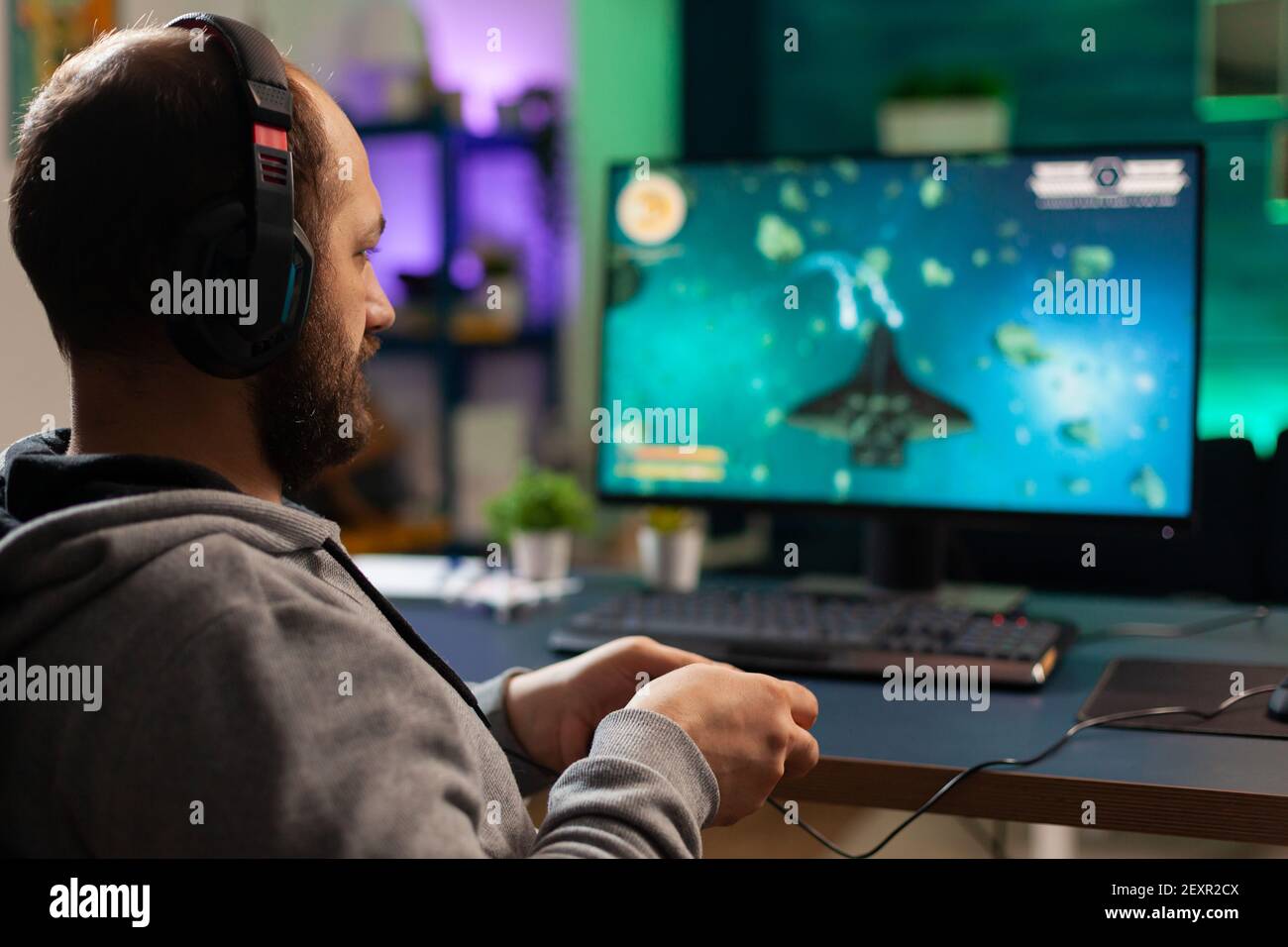 Videogamer spielen Grafik Cyberspace sitzen auf Gaming-Stuhl mit Technologie Netzwerk Wireless. Mann Streaming virale Videospiele zum Spaß mit Kopfhörern und Joystick für Online-Meisterschaft Stockfoto