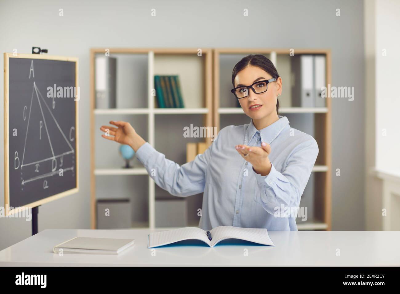 Weibliche Lehrerin für Geometrie erklärt Unterrichtsinformationen während des Online-Unterrichts Stockfoto