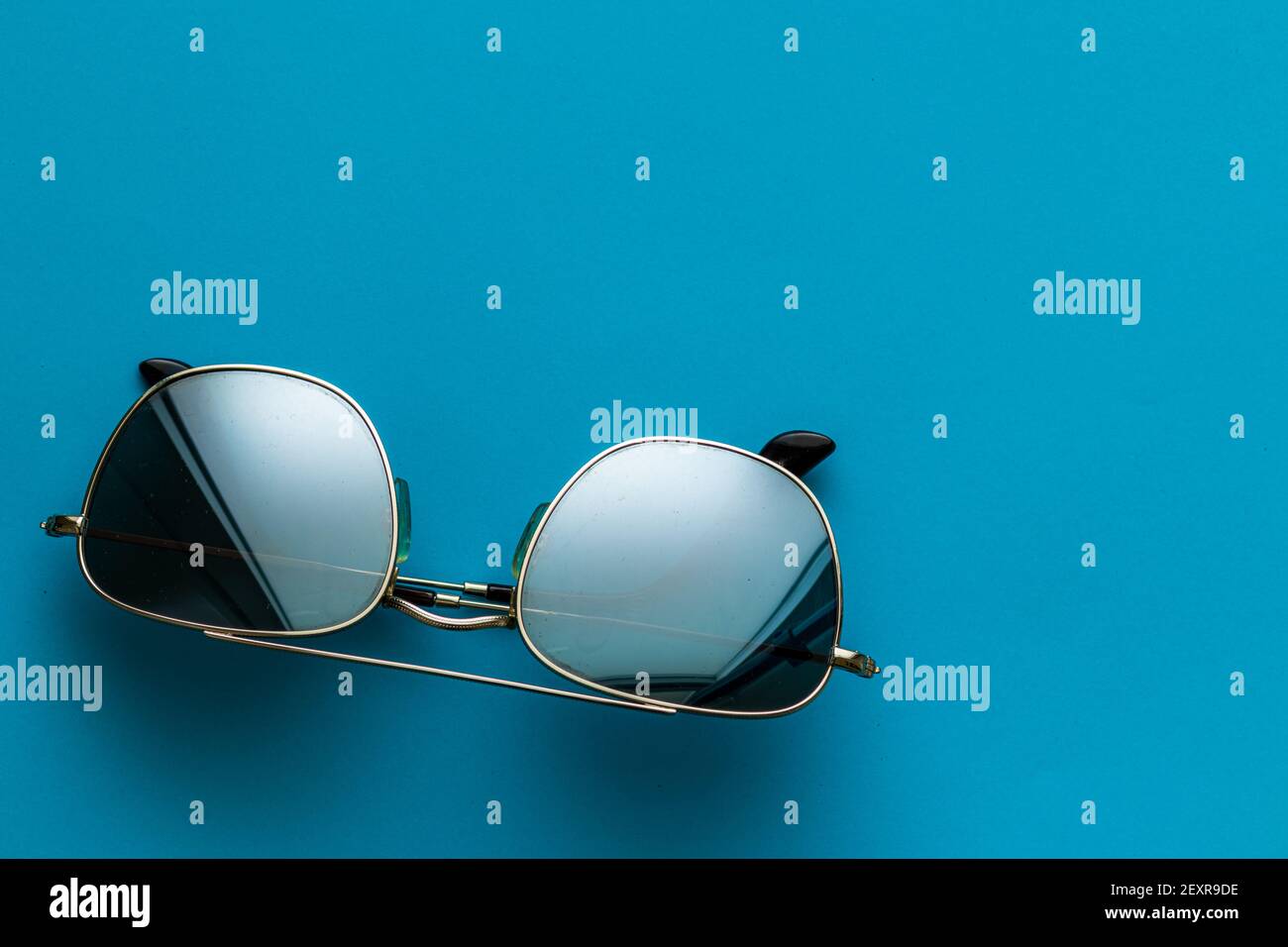 Sonnenbrille. Silber - farbiges Metall, auf blauem Hintergrund Stockfoto