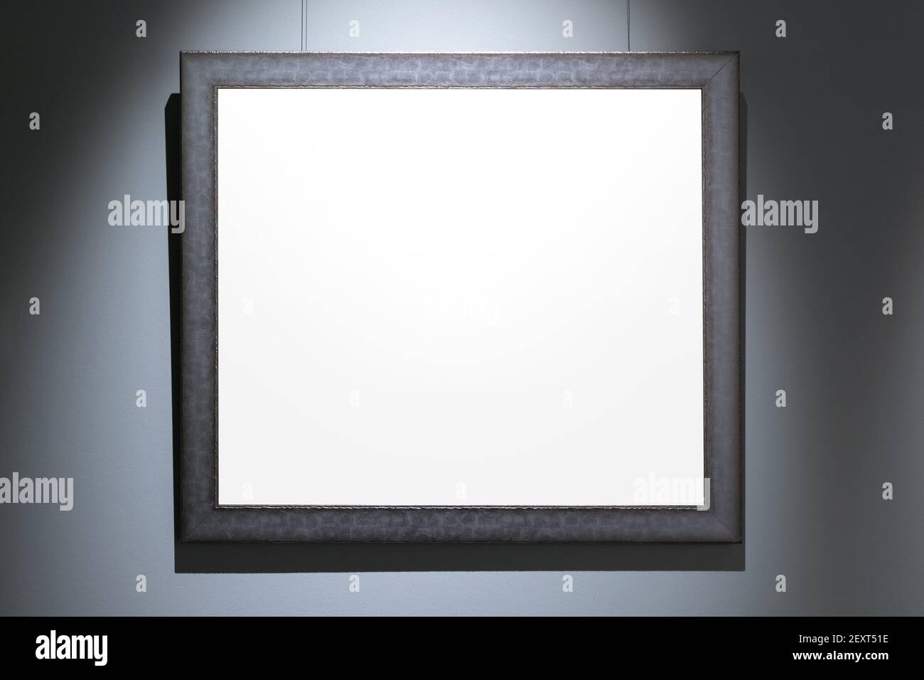 Schwarzer Holzrahmen mit leerem weißen Kopiebereich ist an blauer Wand. Vorderansicht, Hintergrundbild Stockfoto