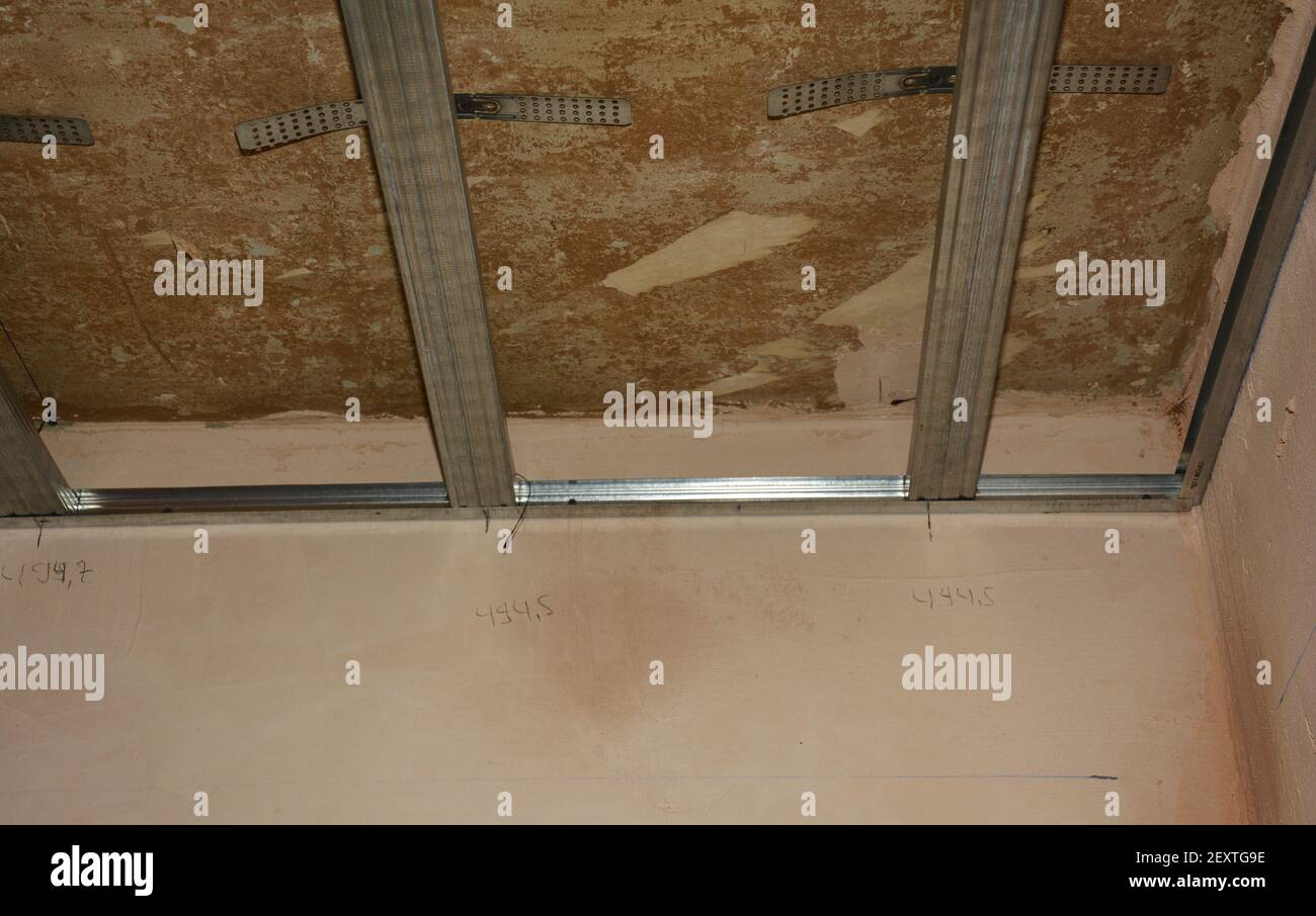 Haus Renovierung und Trockenbau Deckeninstallation: Eine Nahaufnahme von  Metall Stud Rahmen auf verputzten und fertigen Wänden vor dem Aufhängen der  Trockenbau Decke Stockfotografie - Alamy