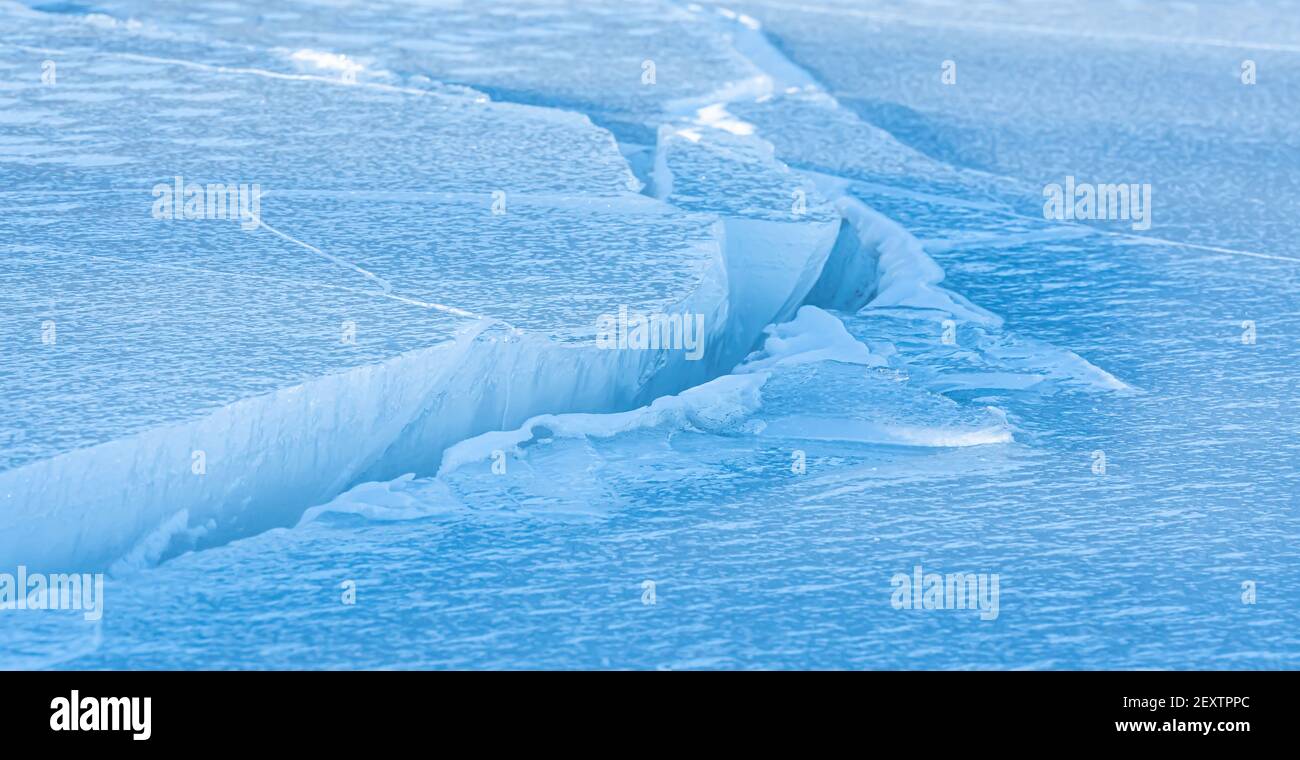 Kühles und klares Meereis mit großen Rissen aus den Gezeiten des Ozeans. Stockfoto