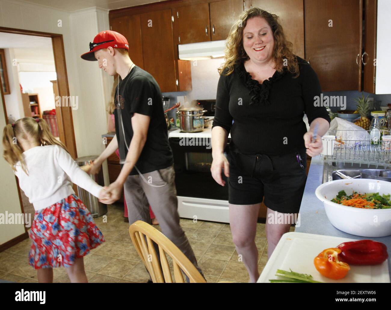 Ellie Edwards, 6, von links, und ihr Bruder Noah Powell, 15, spielen in der Küche, während Charity Edwards, rechts, bereitet die Familie Abendessen am Montag, 19. Mai 2014, in Everett, Washington. Senator Patty Murray (D-WA) vorgeschlagene Gesetzgebung Mittwoch, 21. Mai 2014, Armen Familien $150 pro Kind zu geben, um in den Sommermonaten für Nahrung zu verbringen. (Foto von Kevin Fujii/MCT/Sipa USA) Stockfoto