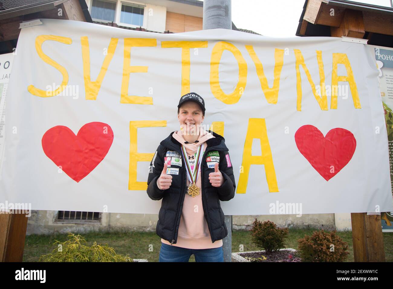 Poljane, Slowenien. Februar 2021, 15th. Die EMA Klinec posiert neben einem großen Banner mit der Aufschrift „World Ema“ in ihrem Heimatdorf Poljane. Die slowenische Ema Klinec, die Weltmeisterin des Skisprungs-Weltmeisters der Frauen 2021, und Nika Kriznar, die Bronzemedaillengewinnerin der Großschanze, kehrten aus Oberstdorf in ihr Heimatdorf zurück, mit Straßen voller Schilder, die Unterstützung zeigten. Kredit: SOPA Images Limited/Alamy Live Nachrichten Stockfoto