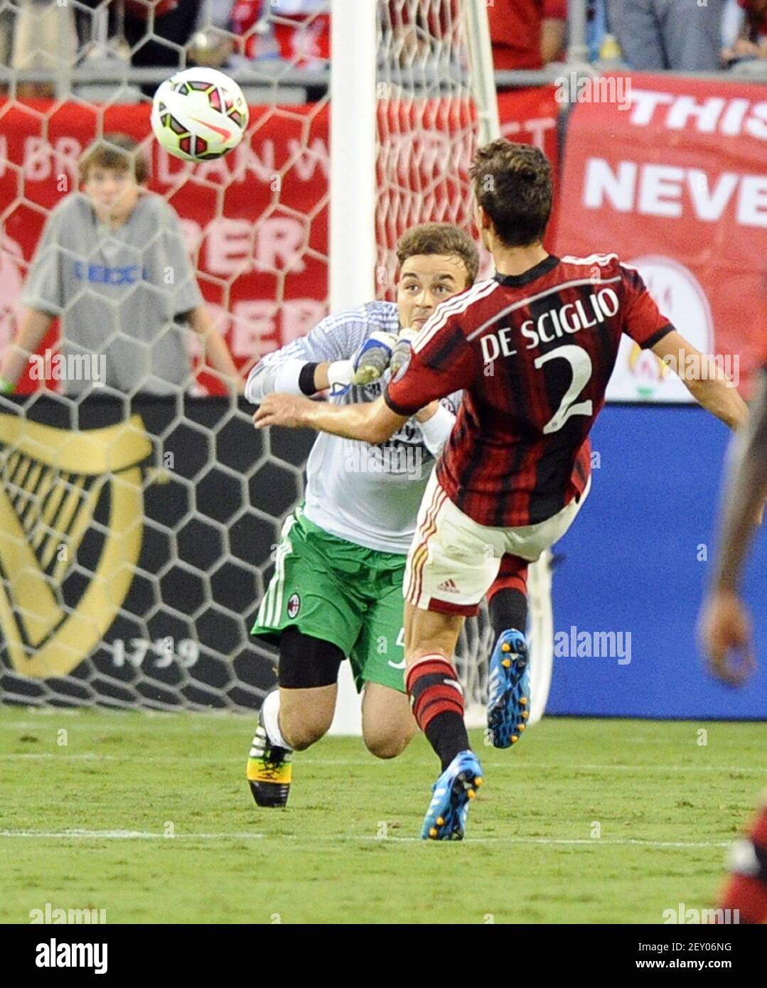AC Mailand Torwart Gabriel Vasconcellos macht ein Spiel auf dem Ball als Teamkollege Mattia De Sciglio (2) schließt in der zweiten Hälfte gegen Liverpool während der International Champions Cup Aktion im Bank of America Stadium in Charlotte, N.C., am Samstag, 2. August 2014. Liverpool gewann, 2-0. (Foto von David T. Foster, III/Charlotte Observer/MCT/Sipa USA) Stockfoto