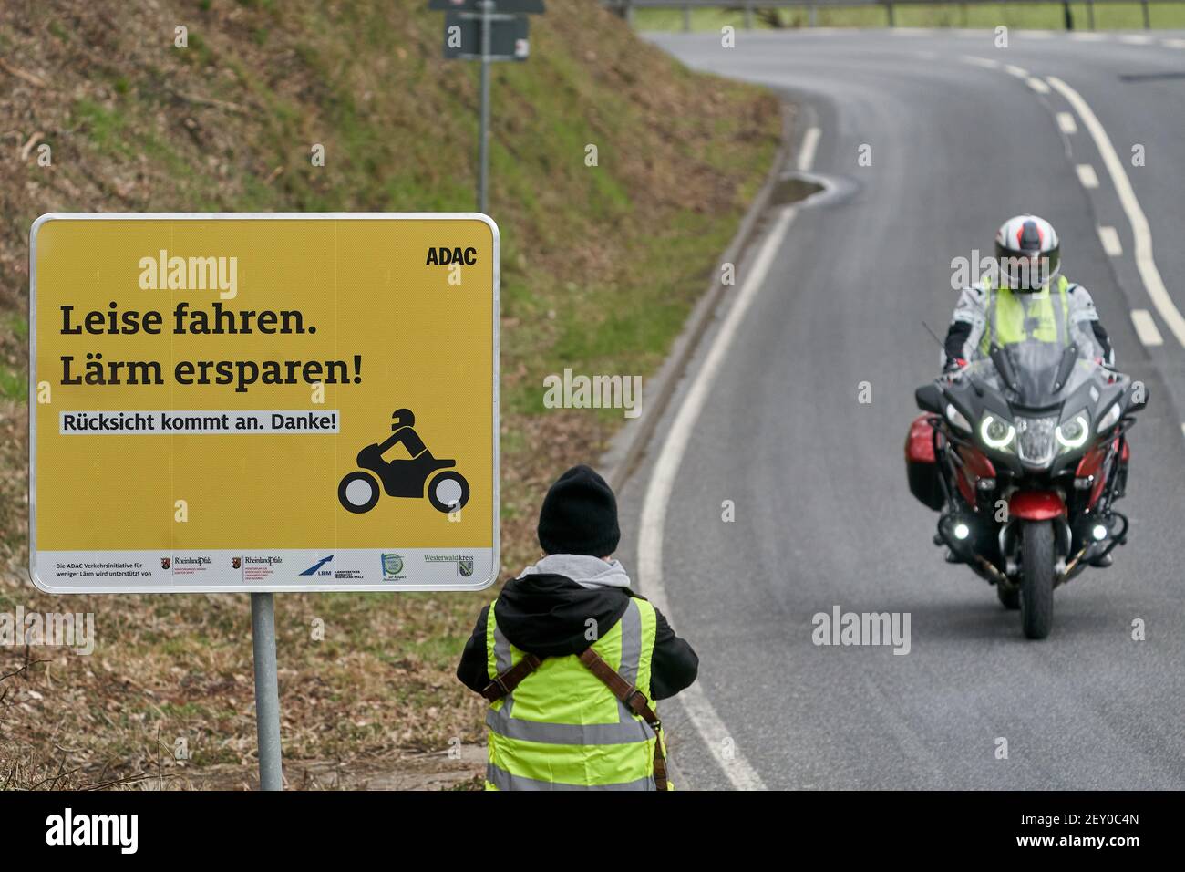 Montabaur, Deutschland. März 2021, 05th. Ein Motorradfahrer fährt an einem  Schild auf der Landstraße im Gelbachtal vorbei und bittet Biker, ruhig und  rücksichtsvoll zu fahren. Vor Saisonbeginn startet der ADAC mit  Unterstützung