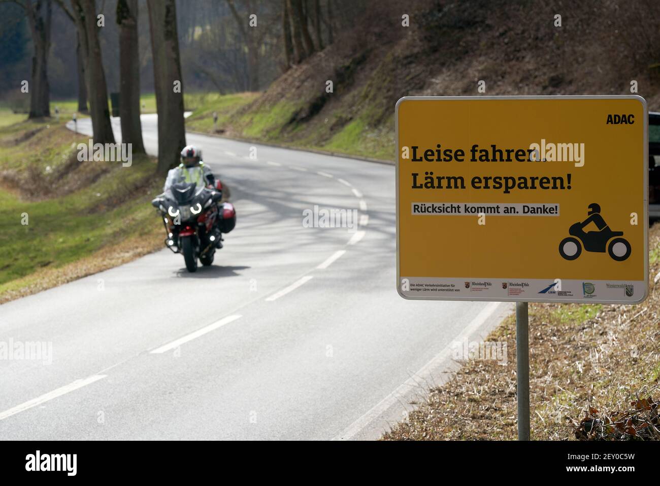 Montabaur, Deutschland. März 2021, 05th. Ein Motorradfahrer fährt an einem  Schild auf der Landstraße im Gelbachtal vorbei und bittet Biker, ruhig und  rücksichtsvoll zu fahren. Vor Saisonbeginn startet der ADAC mit  Unterstützung