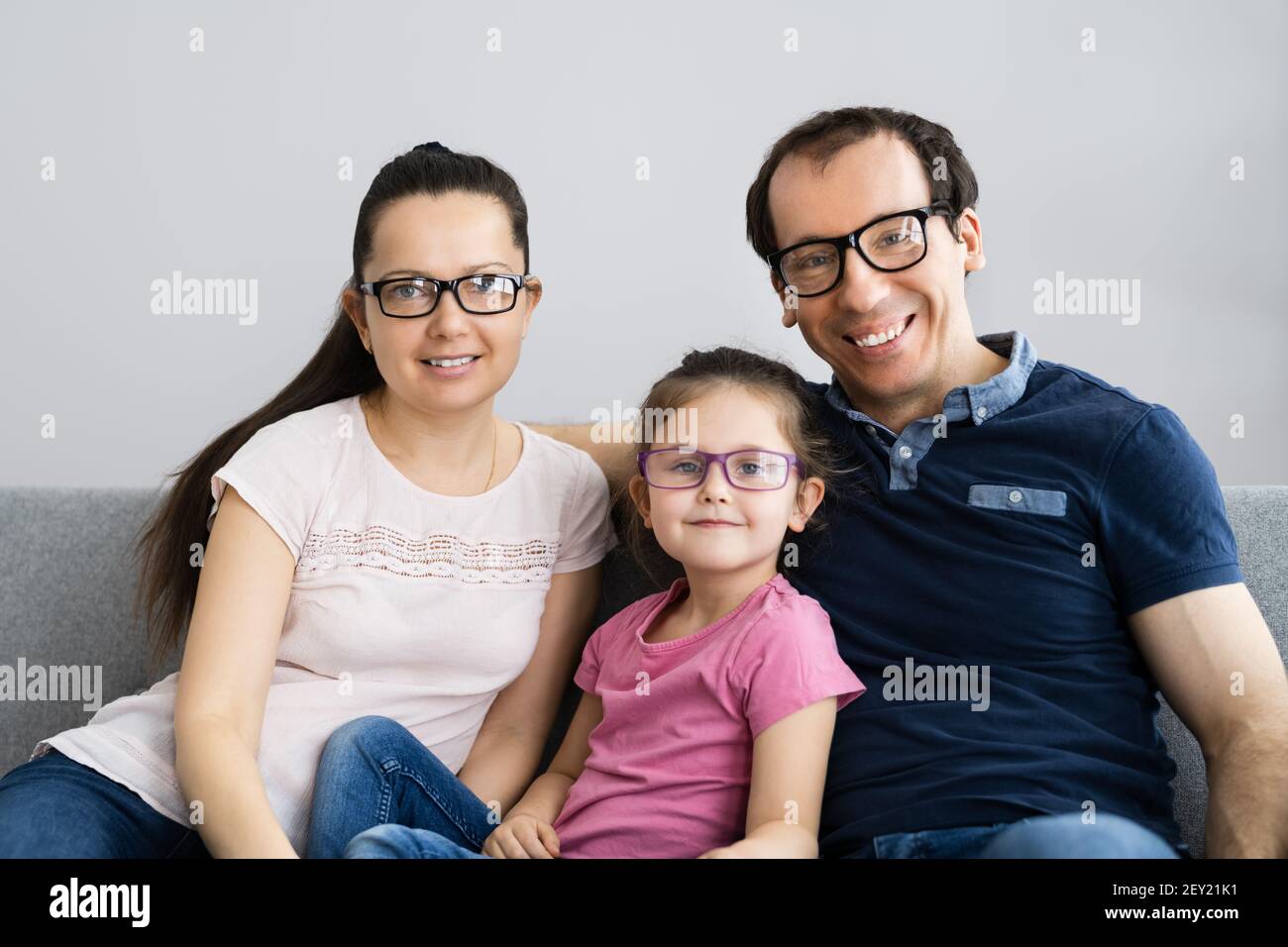 Familie Mit Kind Tochter Trägt Brille Im Wohnzimmer Stockfoto