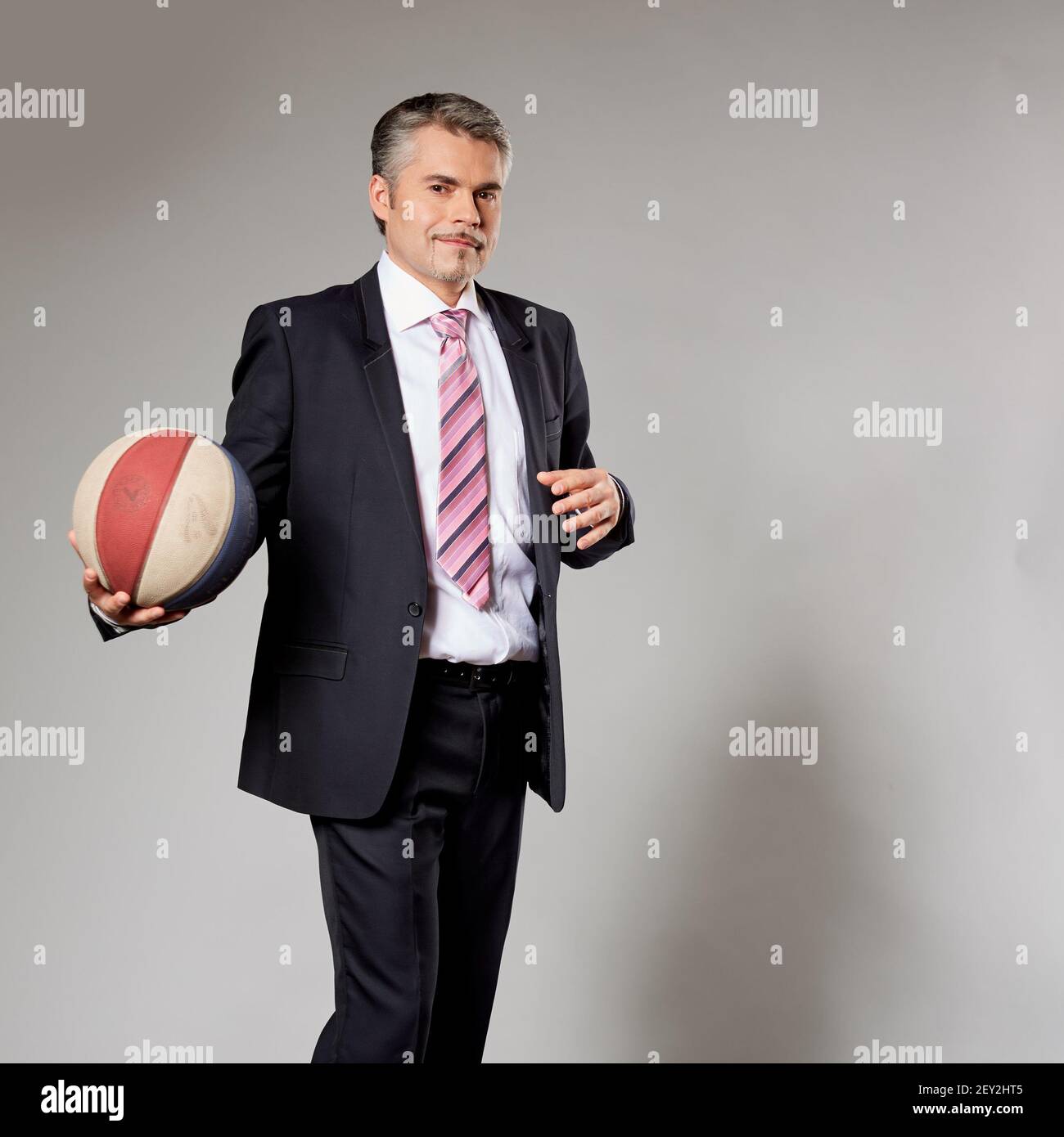 Geschäftsmann mit einem Basketball im Studio spielen Stockfoto