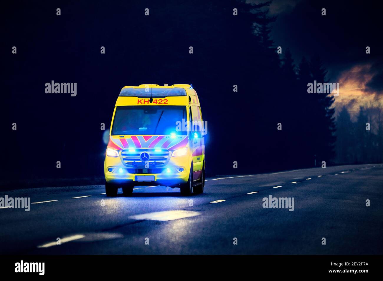 Krankenwagen auf Notruf mit blauen Lichtern blinken auf der dunklen Straße in der Nacht. Marttila, Finnland. 30. Oktober 2020. Stockfoto