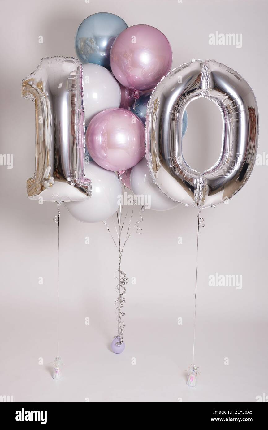 Bunte Pastellballons und Folie Zahl zehn auf grauem Hintergrund Stockfoto