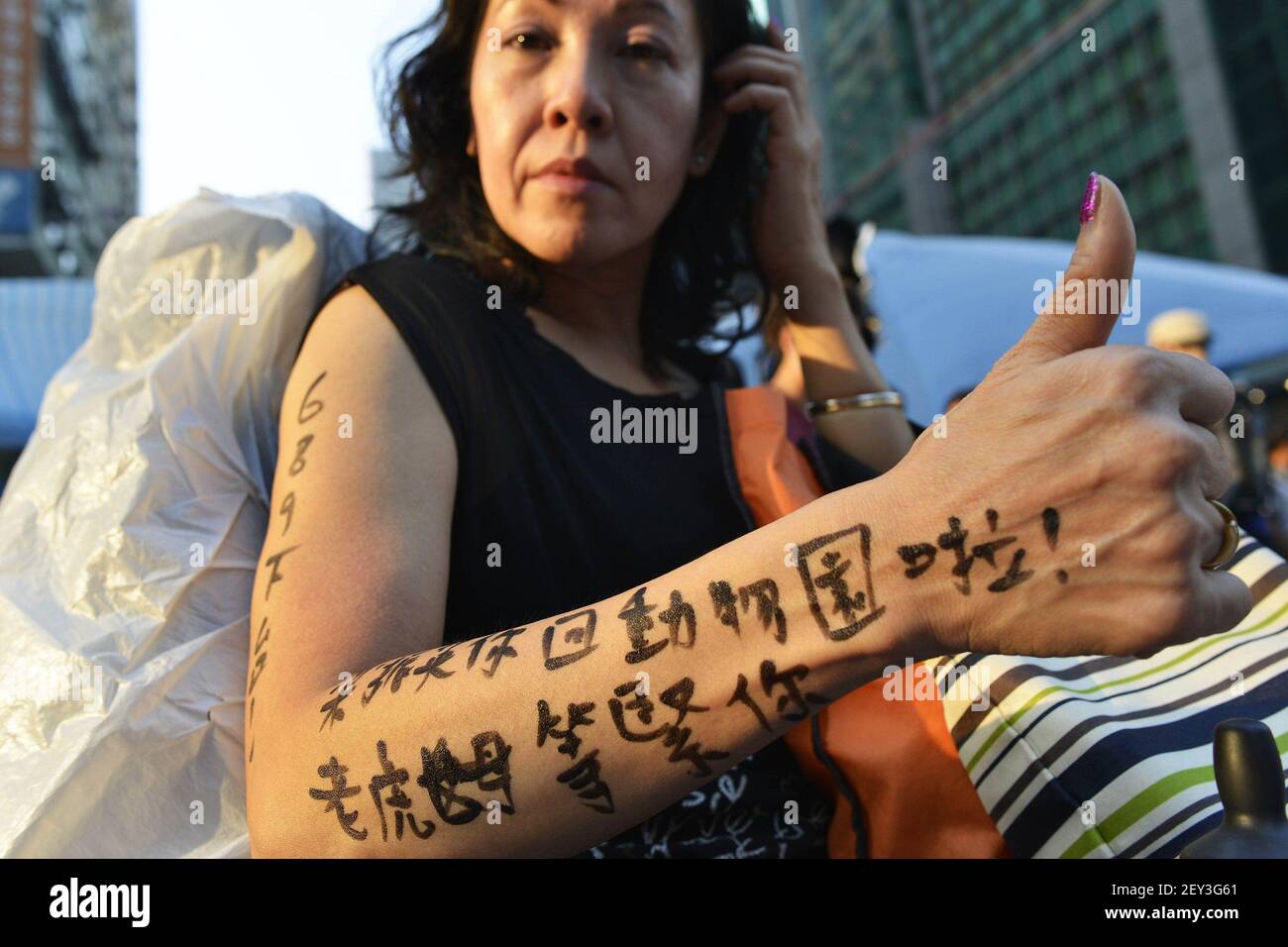 Joyce Ho, die sagt, sie sei drei Tage lang eine Unterstützerin der Demonstranten in Hongkong gewesen, zeigt eine "Tätowierung", die auf Chinesisch die Hongkonger Chefin Leung Chun-Ying auffordert, "in den Zoo zurückzukehren. Tiger Wife wartet auf dich.' Ho wird am Dienstag, den 7. Oktober 2014, auf der prodemokratischen Protestseite in Mong Kok, Hongkong, gesehen. (Foto von Chris Stowers/TNS/Sipa USA) Stockfoto