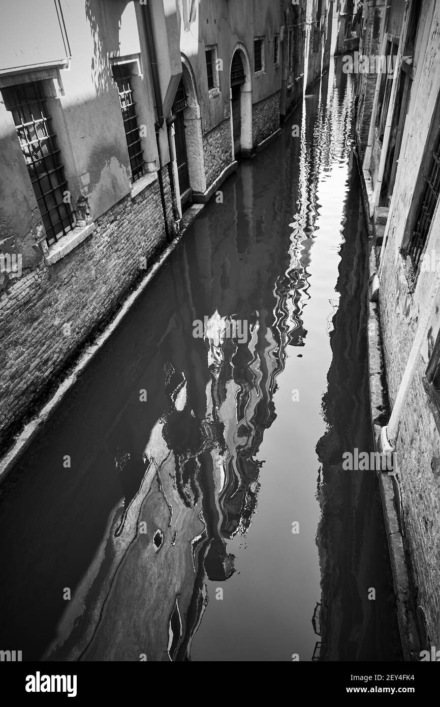 Alte Häuser in Venedig spiegeln sich im Kanalwasser, Italien. Schwarz-Weiß-Fotografie, venezianische Ansicht Stockfoto