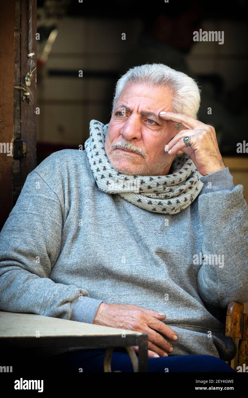 Porträt eines ägyptischen Mannes mit ernster Gesichtsausdruck, der in einem Café (ahwa) im islamischen Viertel von Kairo, Ägypten, sitzt Stockfoto