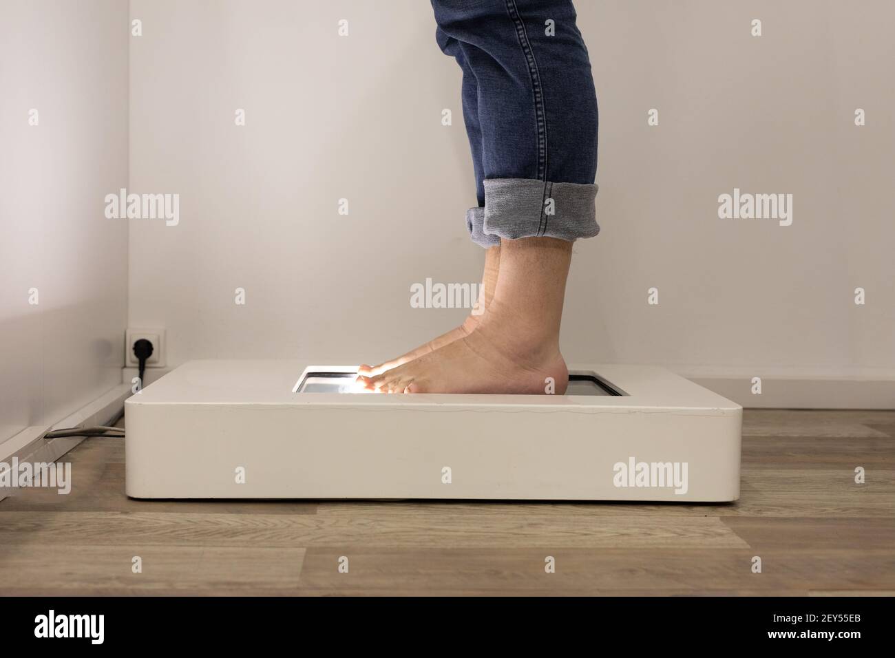 Fußscan zur Bestimmung der exakten Größe und Fußform. Mann, der das elektrische Gerät in einem Schuhgeschäft benutzt. Stockfoto