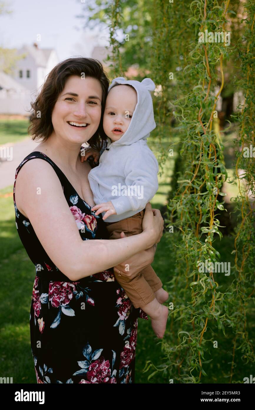 Mutter und kleiner Sohn lächeln und spielen im Vorgarten Im Frühling Stockfoto