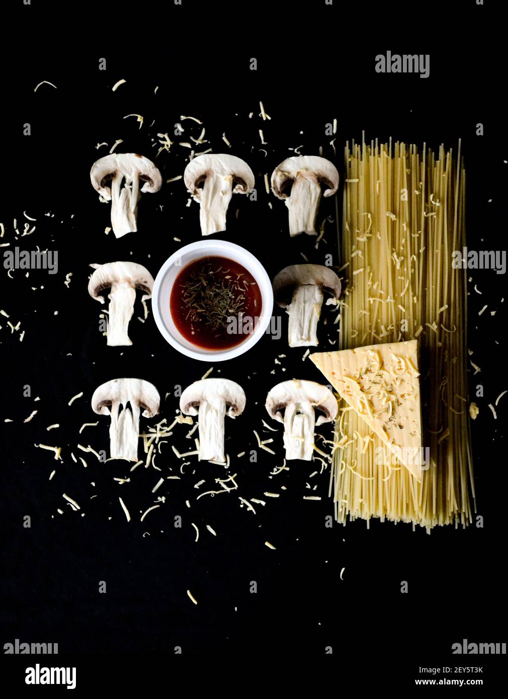 Gehackte Pilze mit Pasta und Käse auf schwarzem Hintergrund Stockfoto