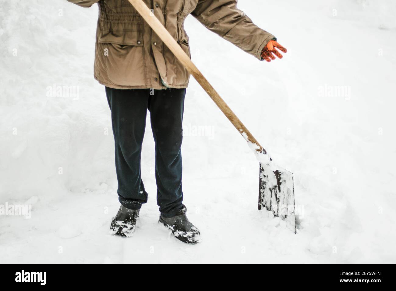 Der Mensch entfernt nach einem Schneesturm Schnee von seinem Hof und schaufelt Schnee Stockfoto