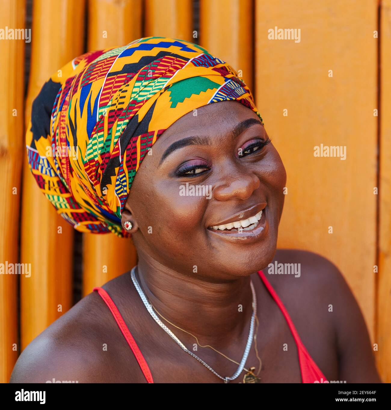 Glückliche afrikanische Frau in dem kleinen Dorf Keta in Ghana, in afrikanischen Kopfschmuck gekleidet Stockfoto