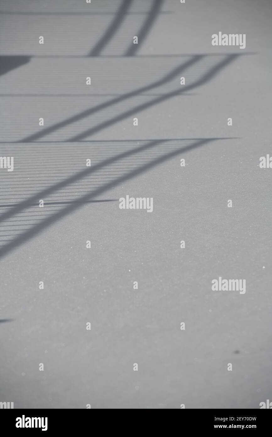 Schatten auf dem äußeren Handgeländer werfen auf neu hereingestürzten Schnee Der Winter erzeugt einen Leitereffekt auf Schneehöden, die erzeugen Eine Perspektive der optischen Täuschung Stockfoto