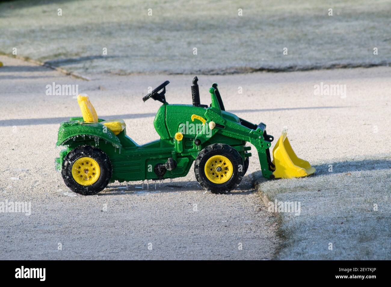 Kinderfahrt auf einem Traktor, der mit Eiszapfen bedeckt ist Stockfoto