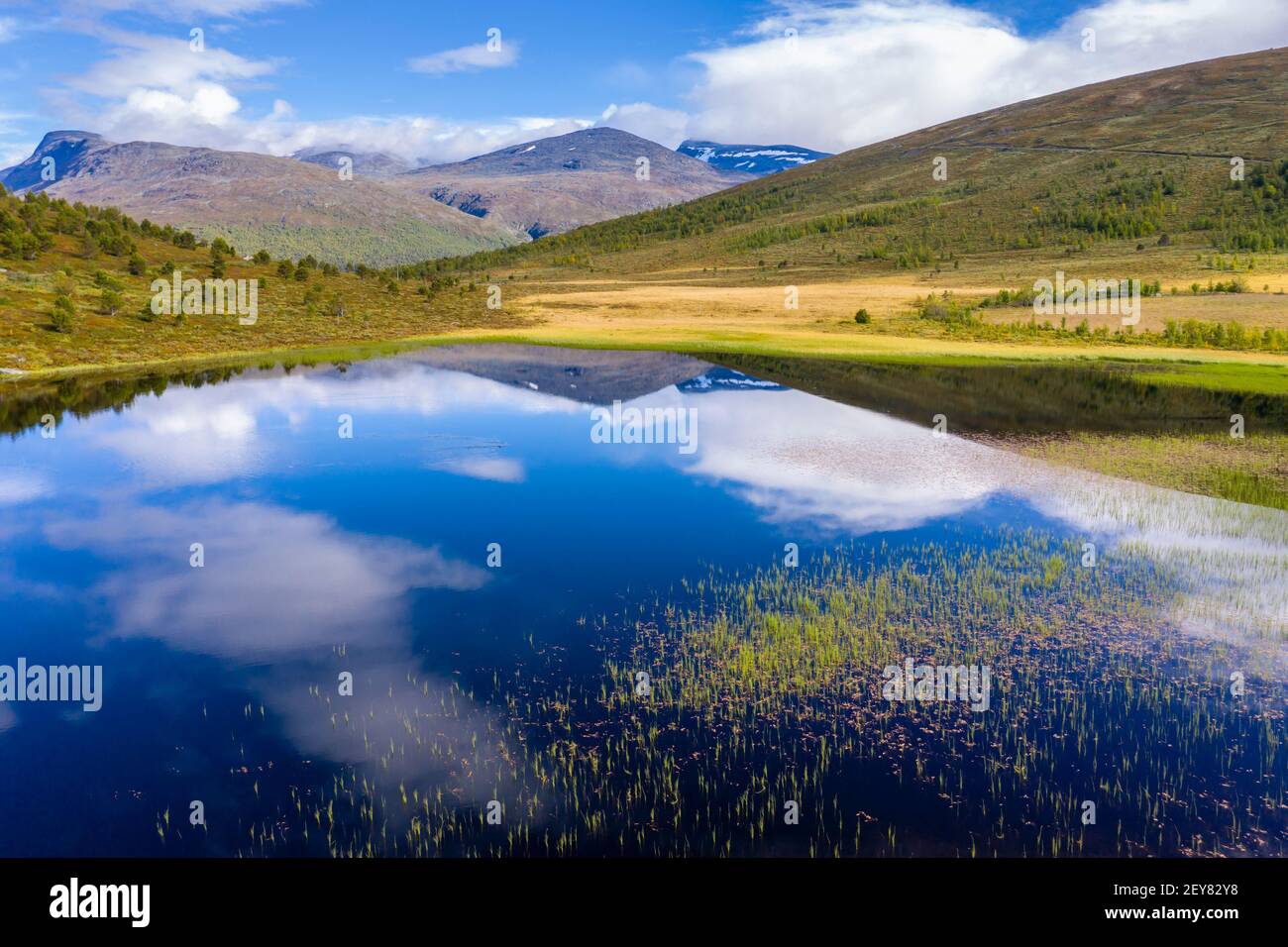 Wolken spiegeln sich auf einem ruhigen See, in der Nähe von Rauberstulen, Jotunheimen Nationalpark, Norwegen Stockfoto