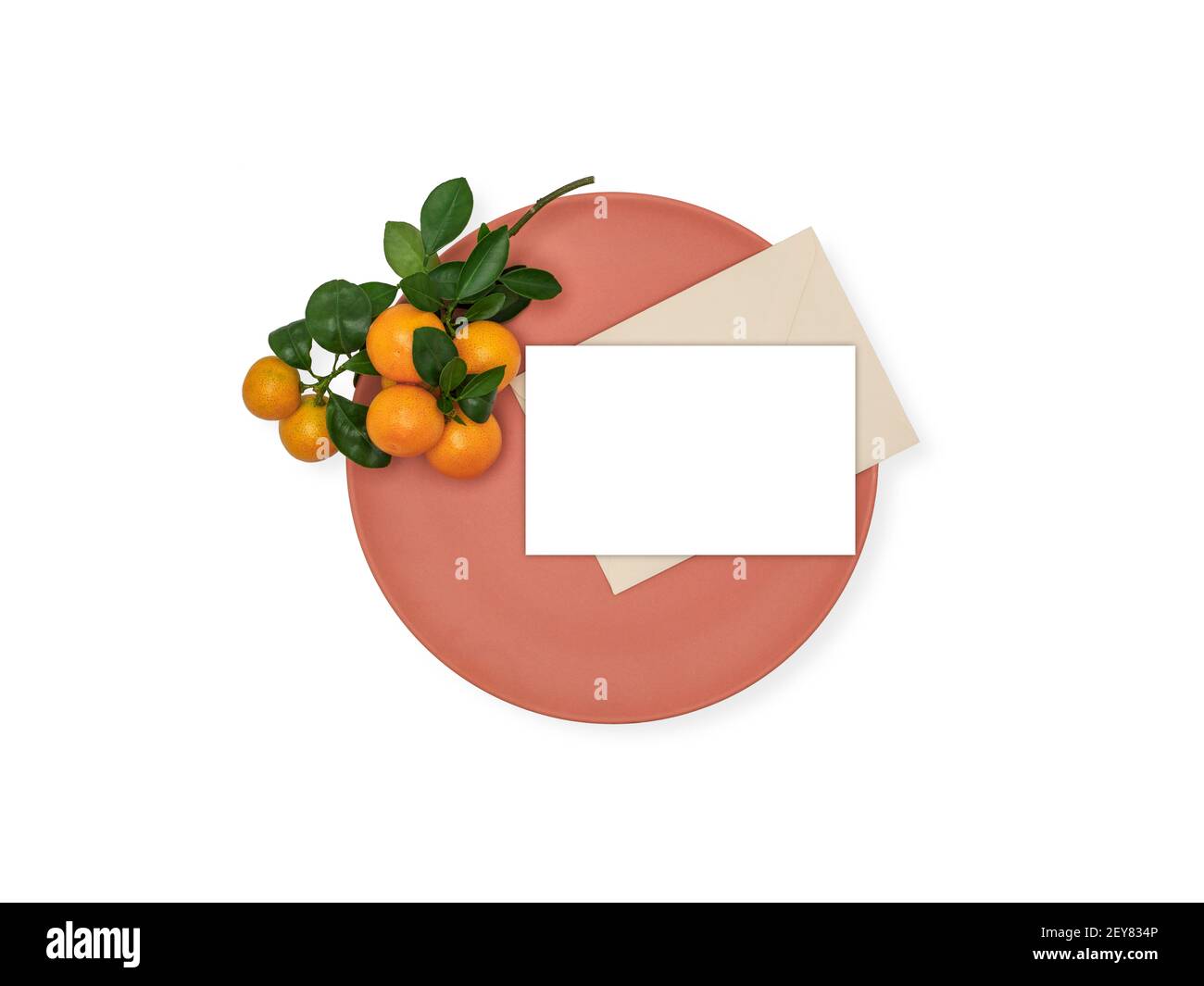 Reife Clementinen mit Kopierraum auf orangefarbener Platte isoliert auf weiß. Citrus clementina, Hybrid aus Mandarine. Gesundes lebendes Mockup. Overhead-Ansicht. Stockfoto